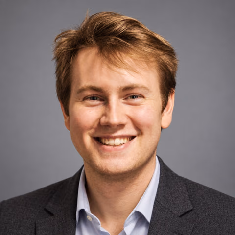 Carl’s approved AI headshot in a charcoal blazer against a gray background
