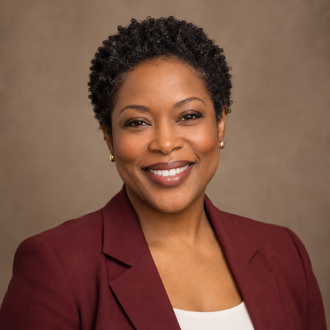 Illustrative AI portrait of a woman in a burgundy blazer against a warm taupe backdrop; fictional person, not a customer result