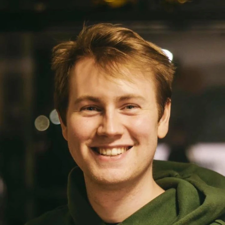 Carl’s reference photo: smiling at the camera in a green hoodie, with a dark indoor background