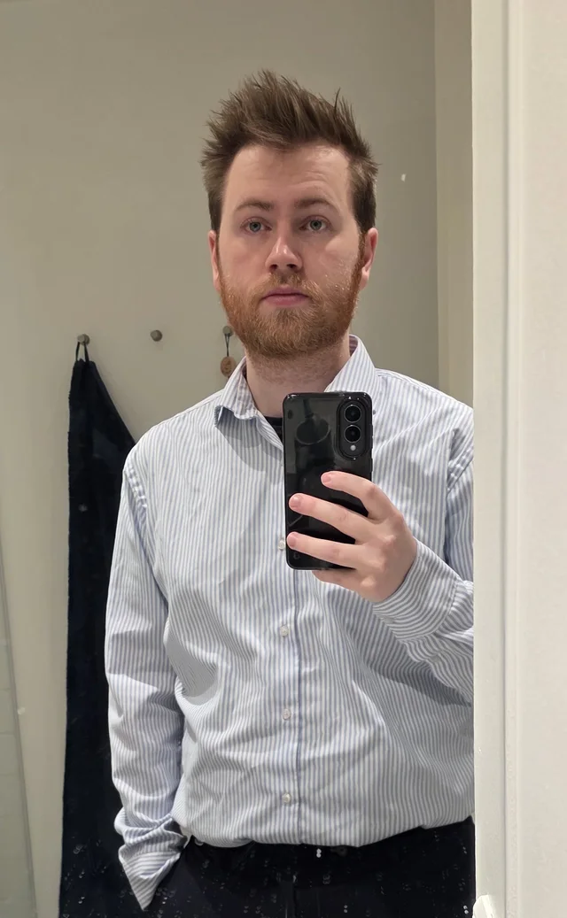 Carl’s original mirror selfie in a striped shirt, holding his phone